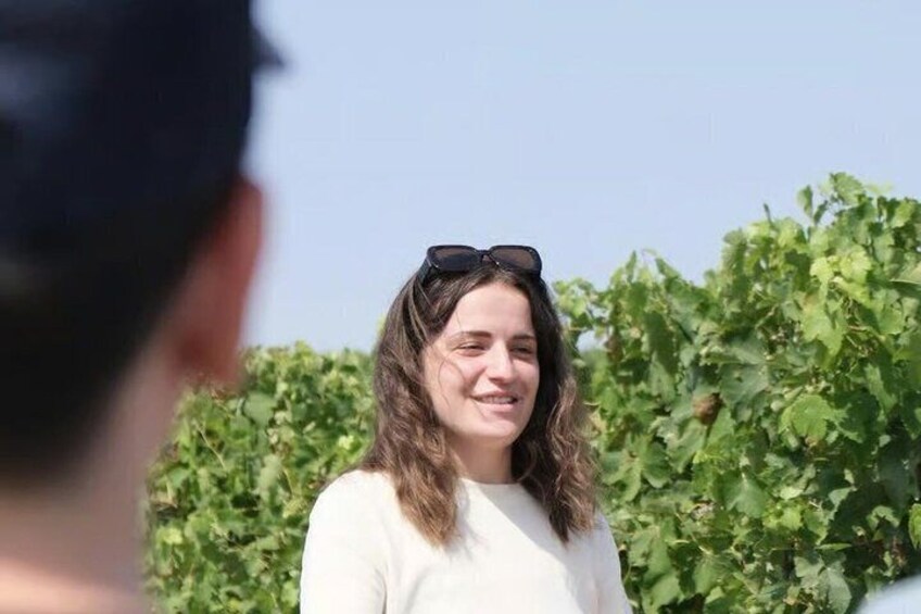 A person standing outdoors with a hedge in the background. 5