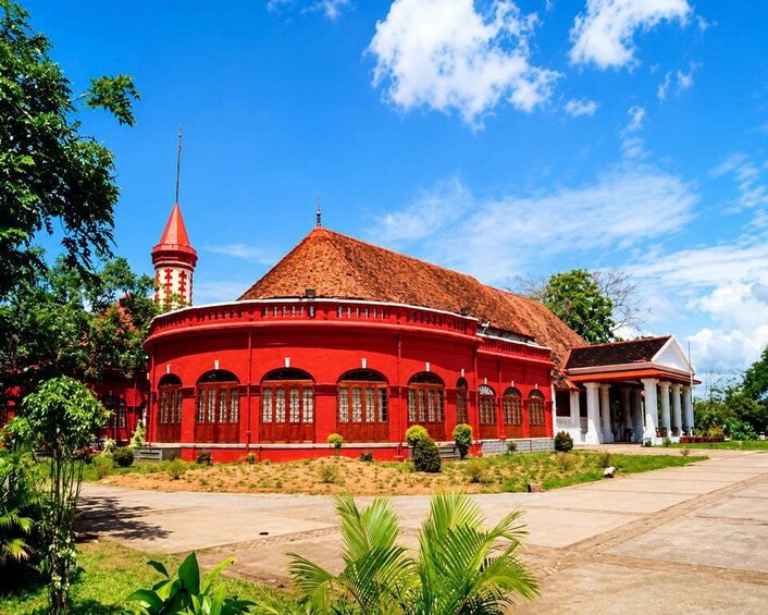 A red building with a tower, surrounded by greenery. 5