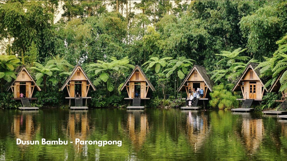 Floating wooden houses on a calm lake surrounded by lush greenery. 4