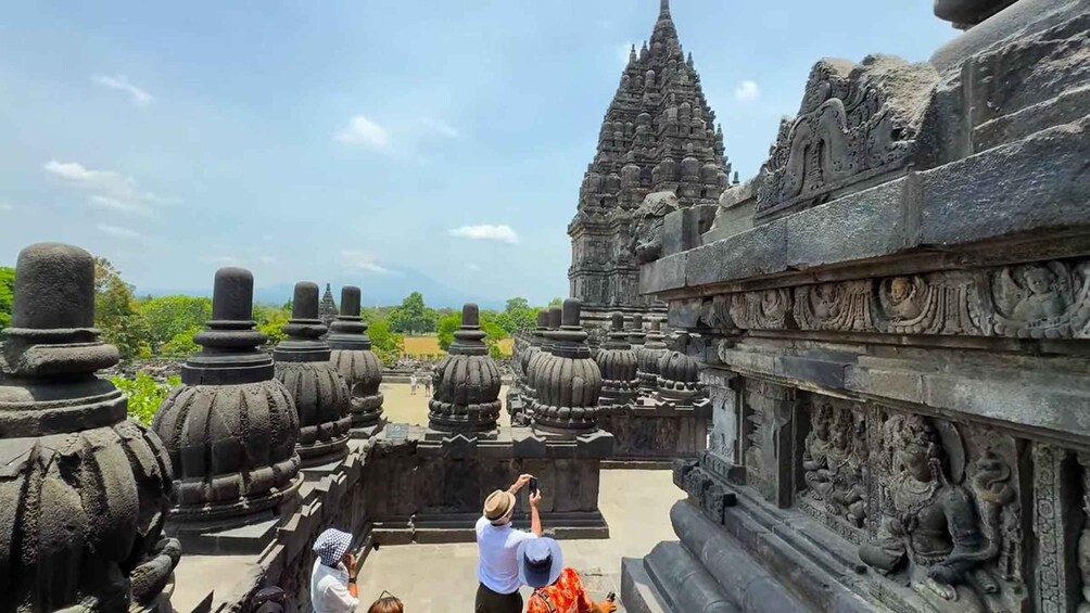 A temple with intricate carvings and a person taking a photo. 3