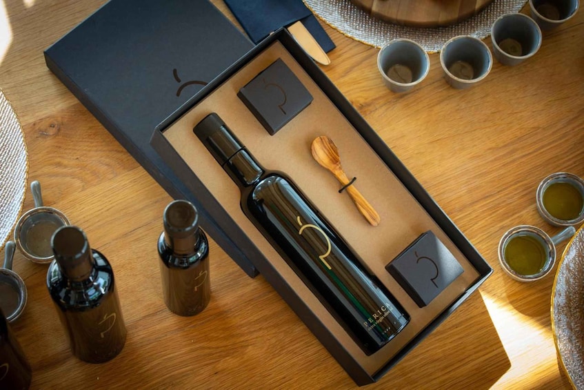 A wooden table with a black box containing a bottle, a wooden spoon, and a black box with a symbol. 4