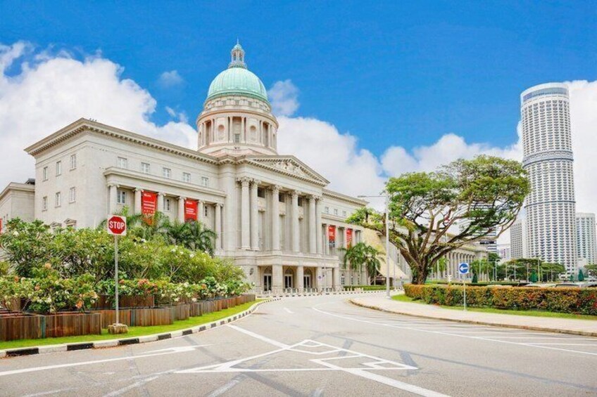 A large government building with a dome, a stop sign, and a tall modern skyscraper in the background. 4