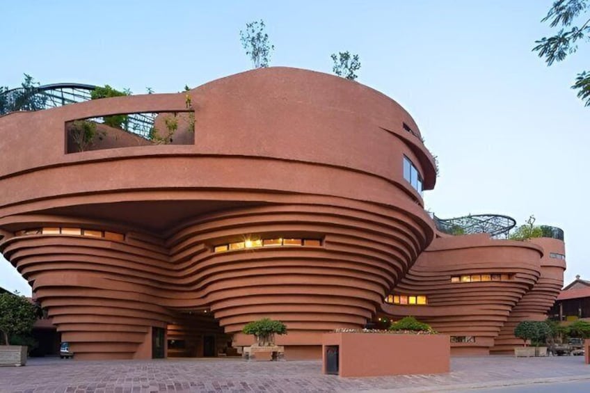 A unique architectural structure with curved, layered design and multiple windows. 4