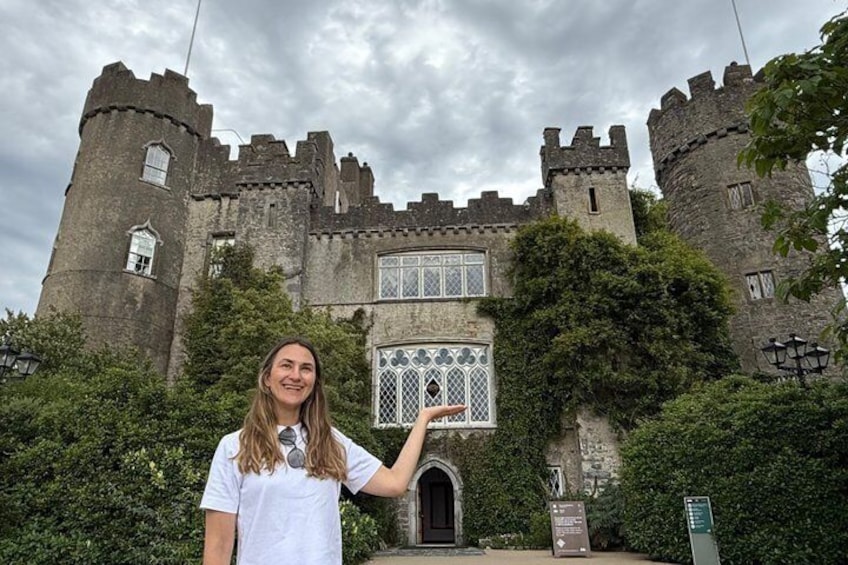 A castle with a large arched window and a person pointing at it. 1