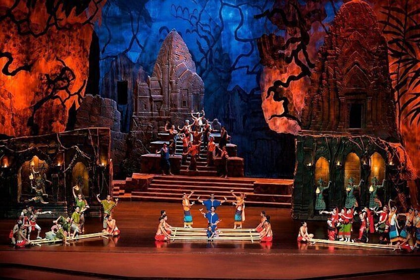 A stage with actors in traditional costumes, a temple-like structure, and a backdrop of trees. 4