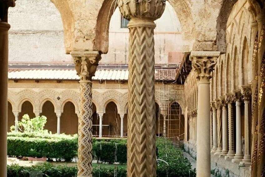 An architectural courtyard with arches and columns. 5