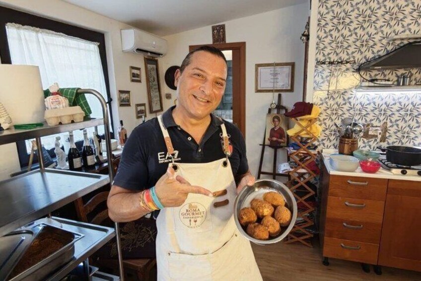 A person in a kitchen holding a bowl of food, with a stove and various kitchen items in the background. 2