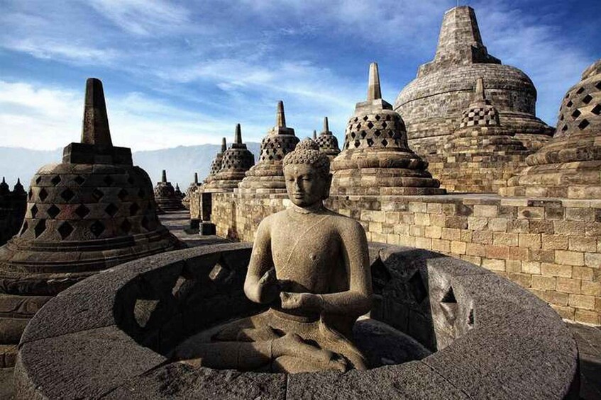 A large stone Buddha statue surrounded by traditional stupa structures. 2