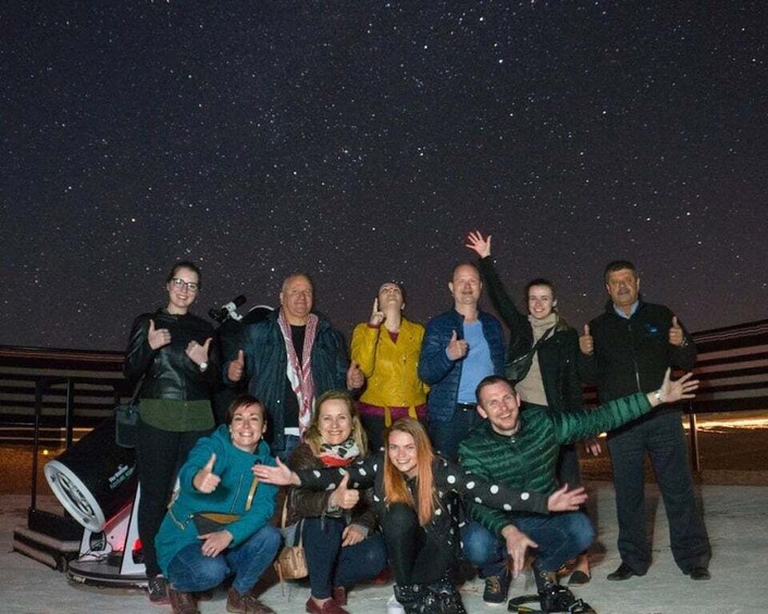 A group of people posing for a photo against a starry night sky. 3