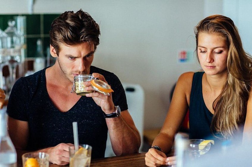 Two people sitting at a table with drinks and a glass of water. 2