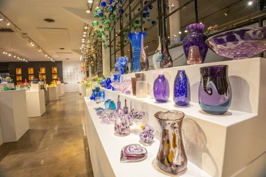 A glass art exhibition with various colorful vases and sculptures on display. 2