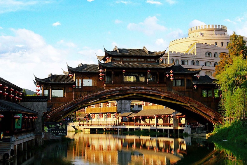 A traditional Chinese bridge over a river, with ornate buildings and a pagoda in the background. 5