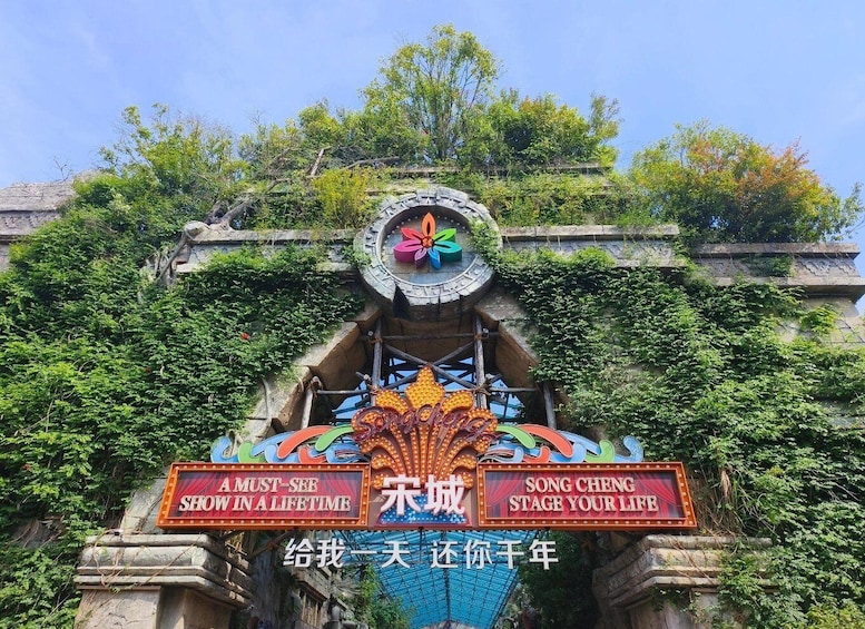 A historic theater entrance with a clock, surrounded by lush greenery. 2