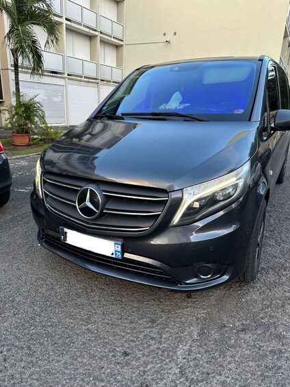 A black Mercedes-Benz SUV parked on a gravel surface with a building in the background. 1
