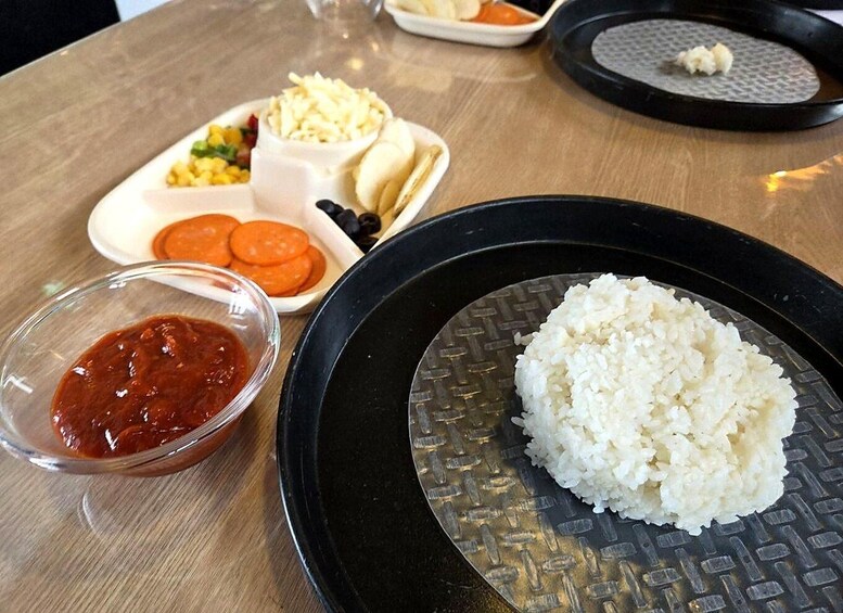 A meal with rice, a bowl of sauce, and various side dishes on a table. 5