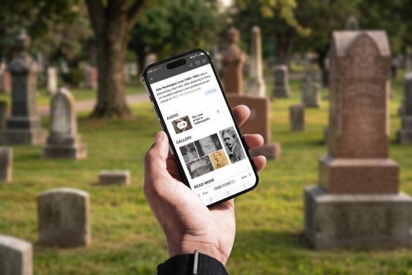 A hand holding a smartphone with a cemetery background. 5
