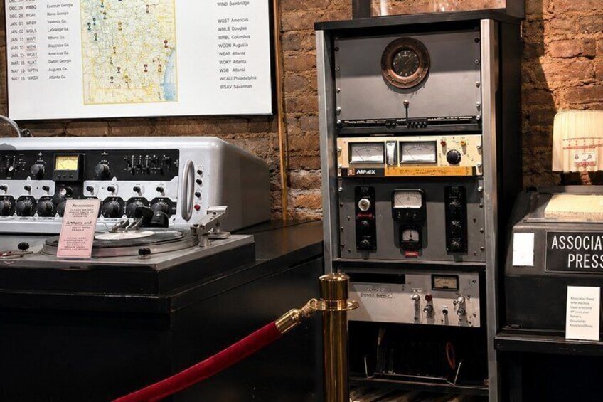 A vintage radio and a clock on a display stand. 3
