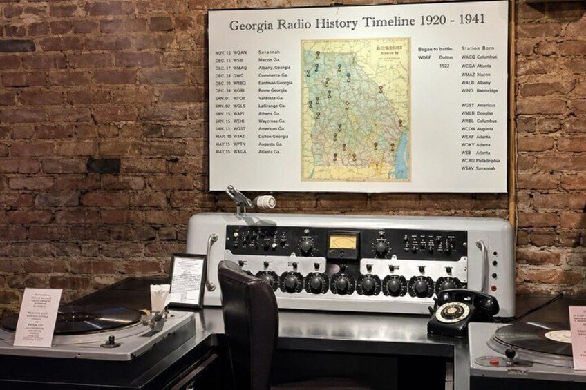A vintage radio with a timeline poster above it. 5