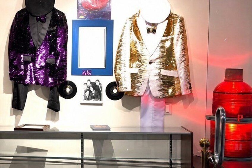 A display of sequined jackets, a framed picture, and a fire extinguisher. 2