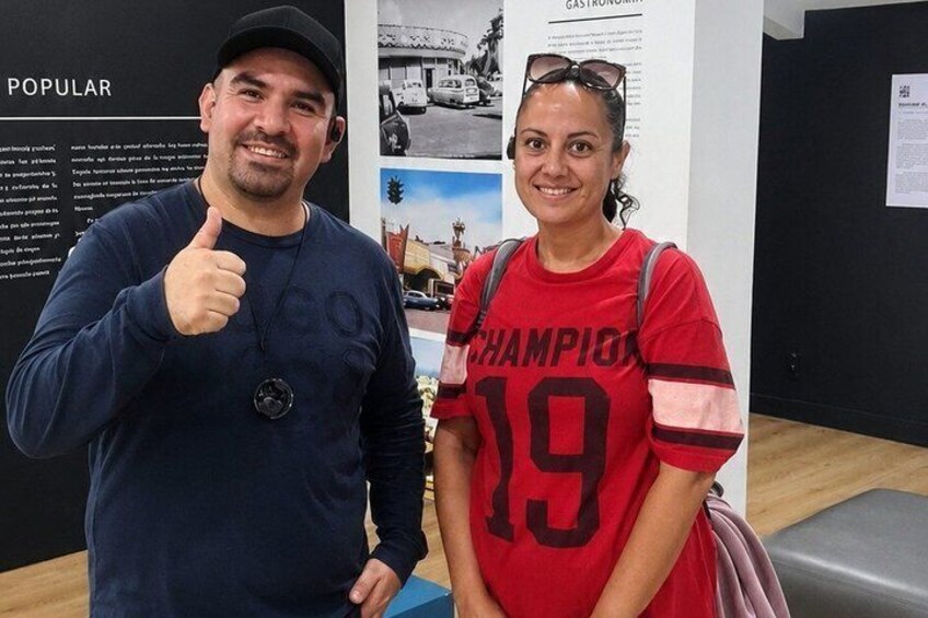 Two people standing in front of a display with text and images. 2