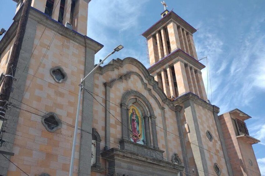 A church with a prominent bell tower and a large arched window with a colorful stained glass design. 5