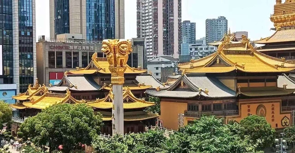 A traditional Chinese temple with golden roofs, surrounded by modern skyscrapers. 5