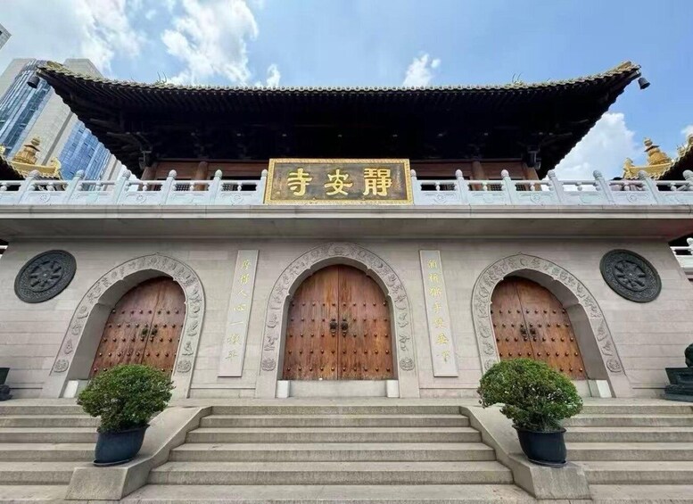 A traditional building with a signboard, arched wooden doors, and a tiled roof. 2