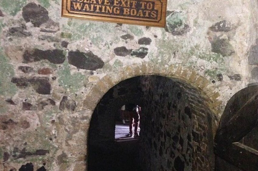 A stone archway with a sign above it that reads 'EXIT TO WAITING BOATS.' 4