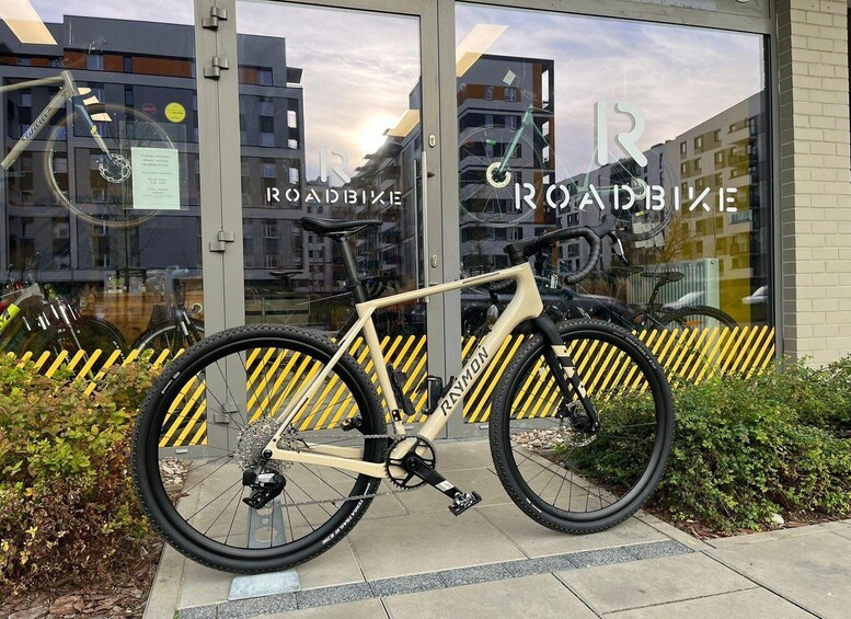 A road bike parked in front of a building with large windows. 3