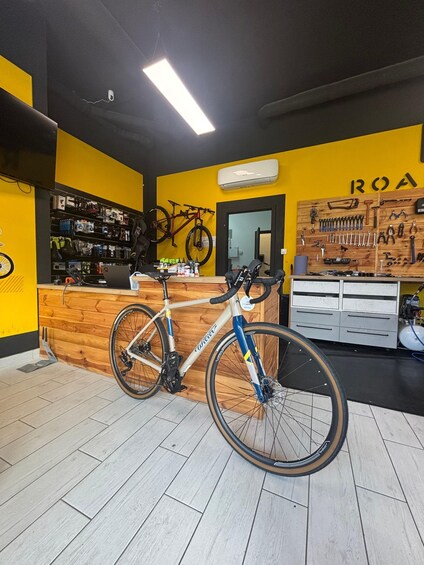 A bicycle repair shop with a wooden counter, tools, and a bicycle. 2