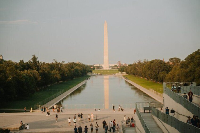 The Washington Monument with a river in the foreground and trees on both sides. 4