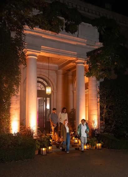 A grand entrance with columns, a door, and people standing outside. 3