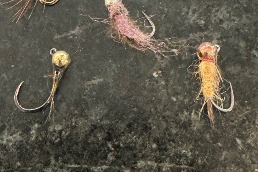 Three fishing lures on a dark surface. 2