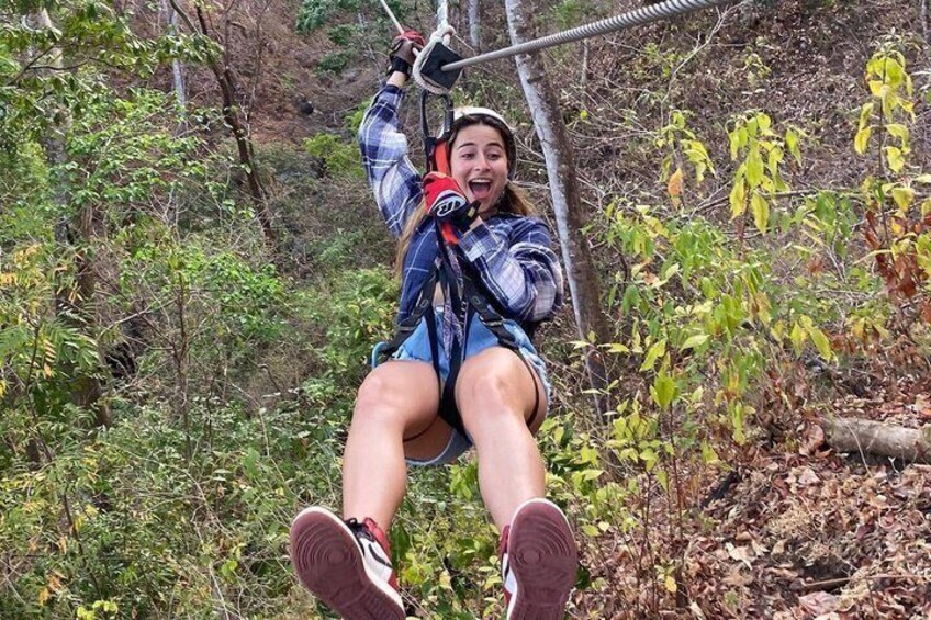 A person on a zip line in a forested area. 5
