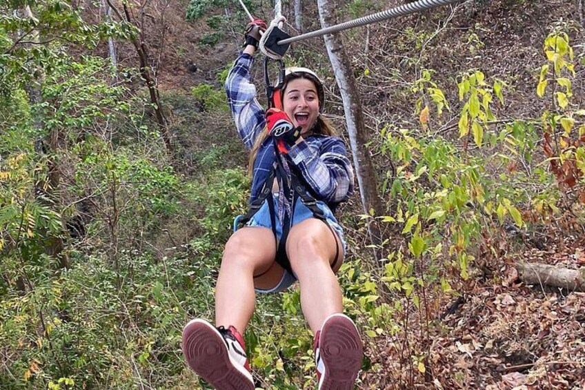 A person on a zip line in a wooded area. 5