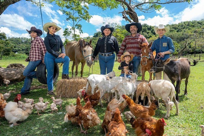 A group of people with horses and livestock in a grassy field. 1