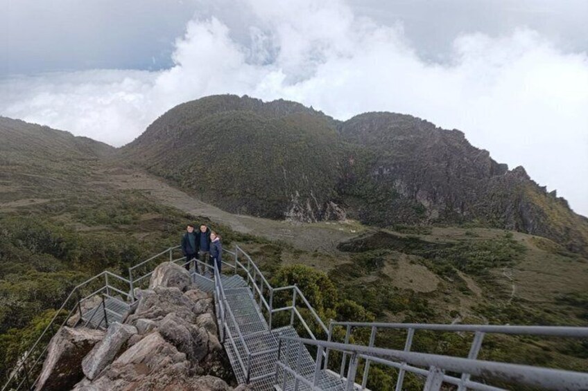 A metal staircase leading up a mountain with two people standing at the top. 2