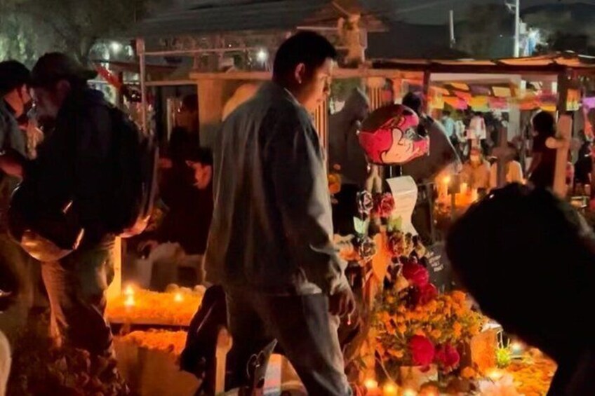 A nighttime outdoor market with people and stalls. 5