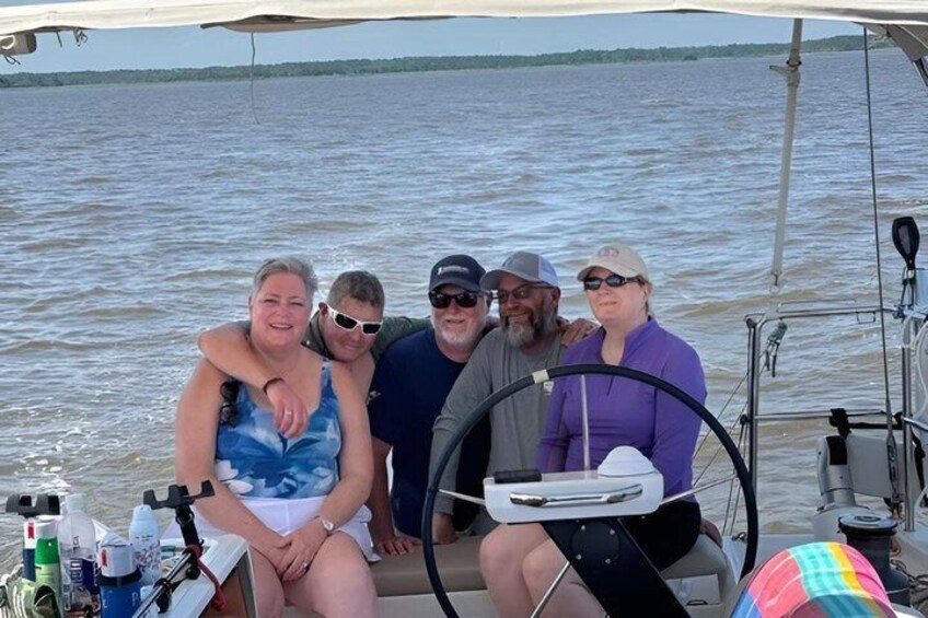 A group of people on a boat with a water body in the background. 3