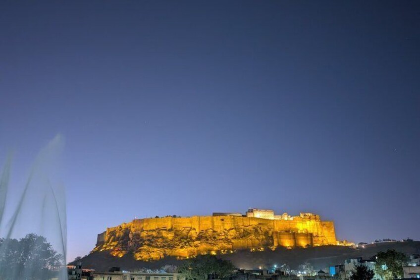 A large illuminated fort or castle at dusk. 4
