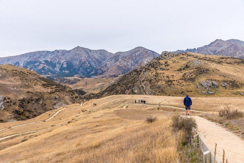 A hiker on a trail with mountains in the background. 2