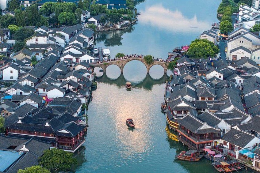 A riverside town with traditional buildings, a bridge, and boats. 4