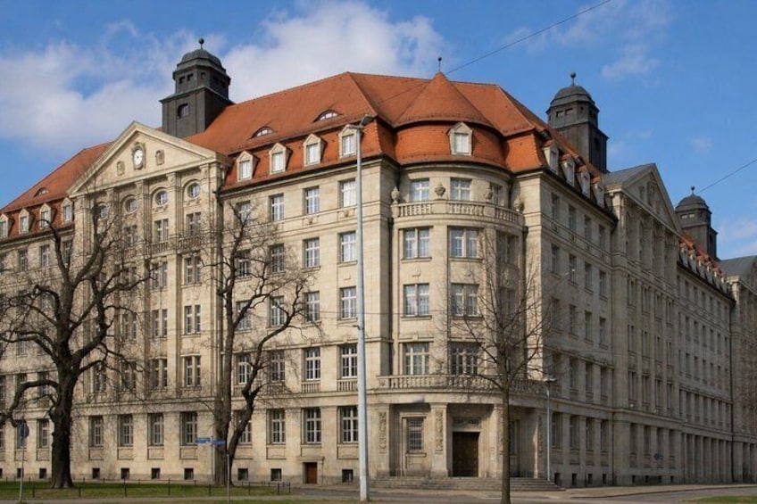 A historic building with a red-tiled roof, multiple windows, and two prominent towers. 2