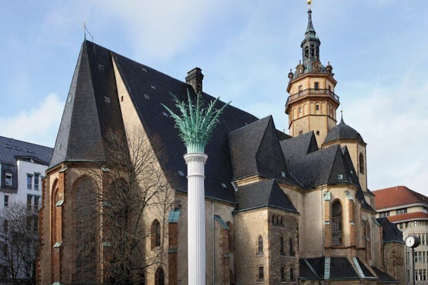 A historic church with a tall tower and a statue in front. 4