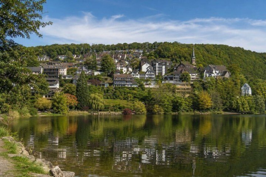 A lakeside town with buildings, trees, and a church. 5
