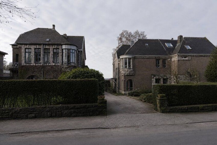 A residential street with two houses, one with a turret and another with a gabled roof. 3