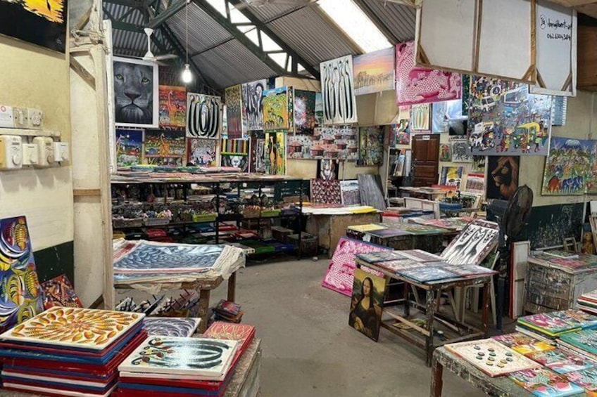 A craft market with various handmade items and artworks displayed on tables and shelves. 3