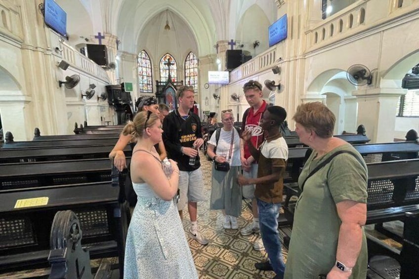 A group of people inside a church with pews and a high arched ceiling. 4