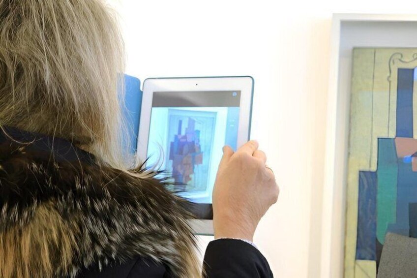 A person holding a tablet displaying an artwork. 2