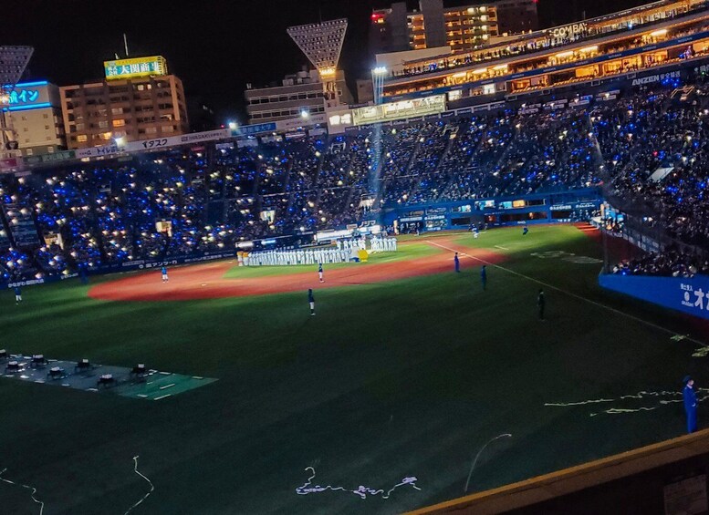 A baseball stadium at night with a crowd of spectators. 4